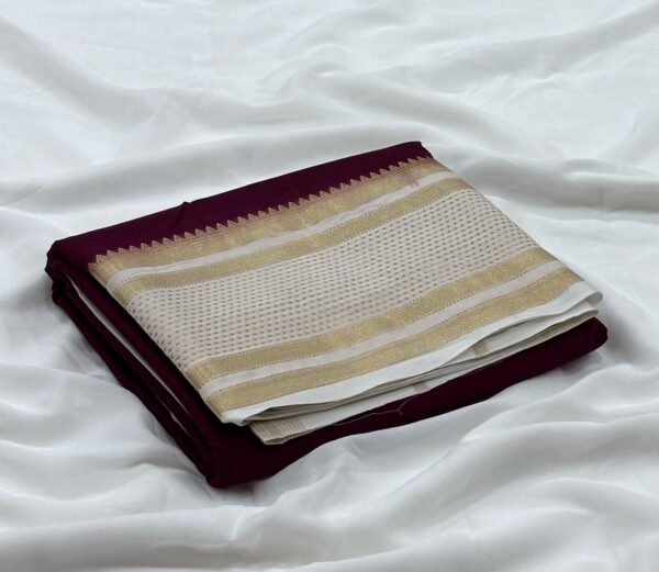 a folded fabric on a white sheetPremium Mysore silk saree In Coffee Brown With White