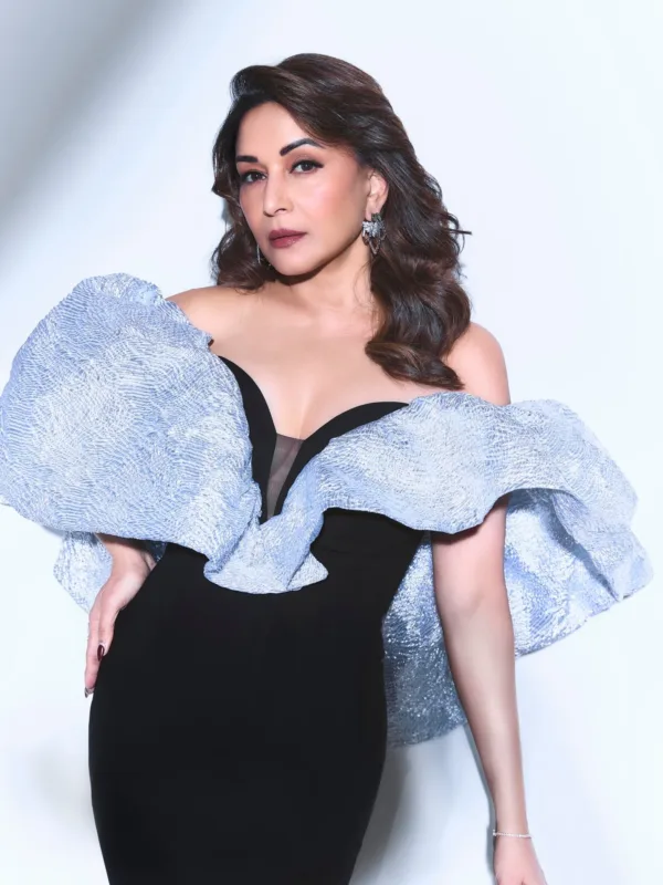 Madhuri Dixit Nene wearing a black evening gown with dramatic metallic ruffle shoulders and statement diamond earrings on the red carpet.