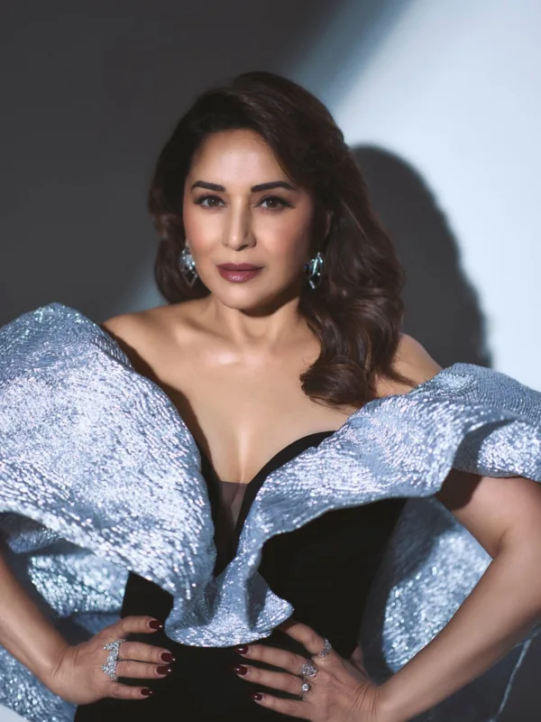Madhuri Dixit Nene wearing a black evening gown with dramatic metallic ruffle shoulders and statement diamond earrings on the red carpet.