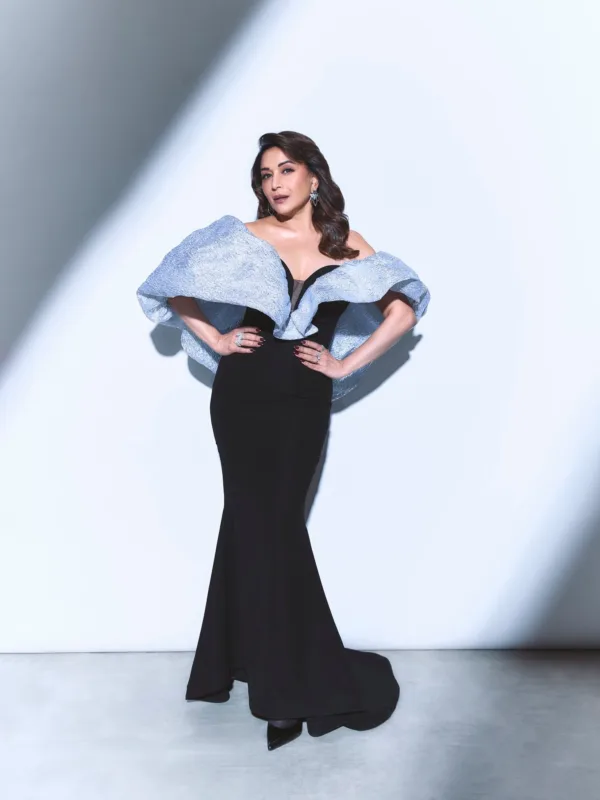 Madhuri Dixit Nene wearing a black evening gown with dramatic metallic ruffle shoulders and statement diamond earrings on the red carpet.